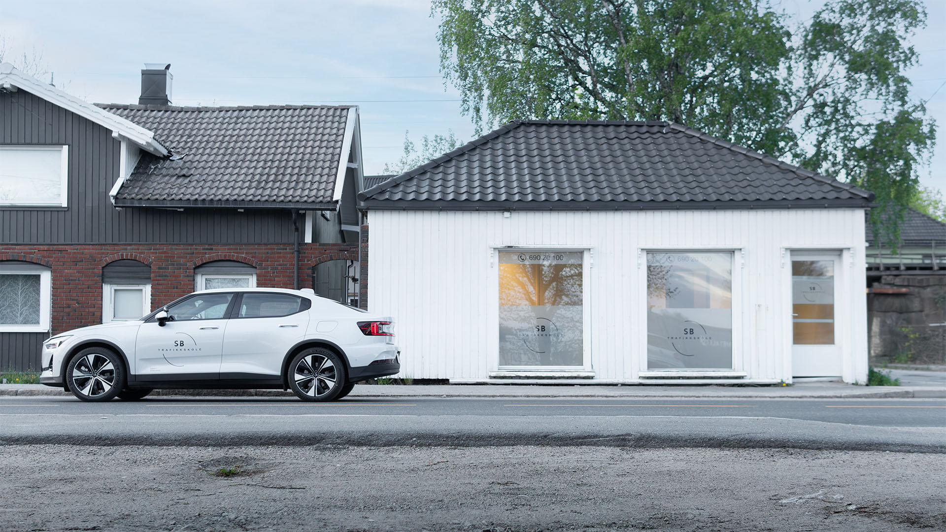 Bil til SB Trafikkskole i Sarpsborg, en hvit Polestar står parkert utenfor lokalet til SB Trafikkskole på Greåker i Sarpsborg